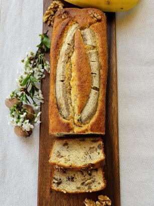 Freshly baked Banana Walnut Bread sliced and displayed on a wooden board.