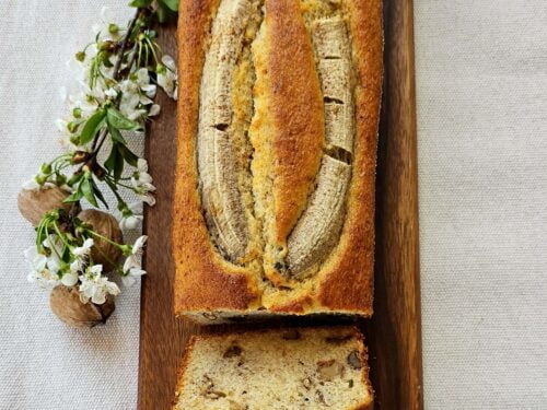 Freshly baked Banana Walnut Bread sliced and displayed on a wooden board.