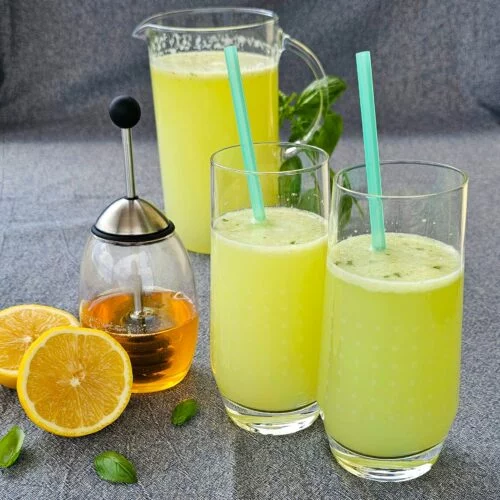 Limonadă proaspătă servită cu gheață, felii de lămâie și frunze de mentă într-un pahar.