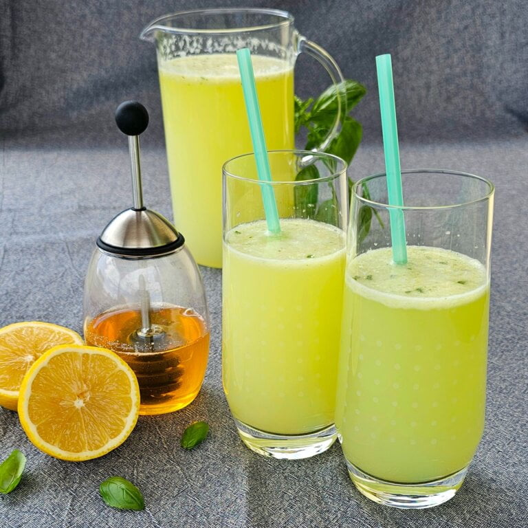 Limonadă proaspătă servită cu gheață, felii de lămâie și frunze de mentă într-un pahar.