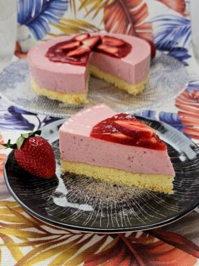 Strawberry Bavarois topped with fresh strawberries and a drizzle of berry sauce.