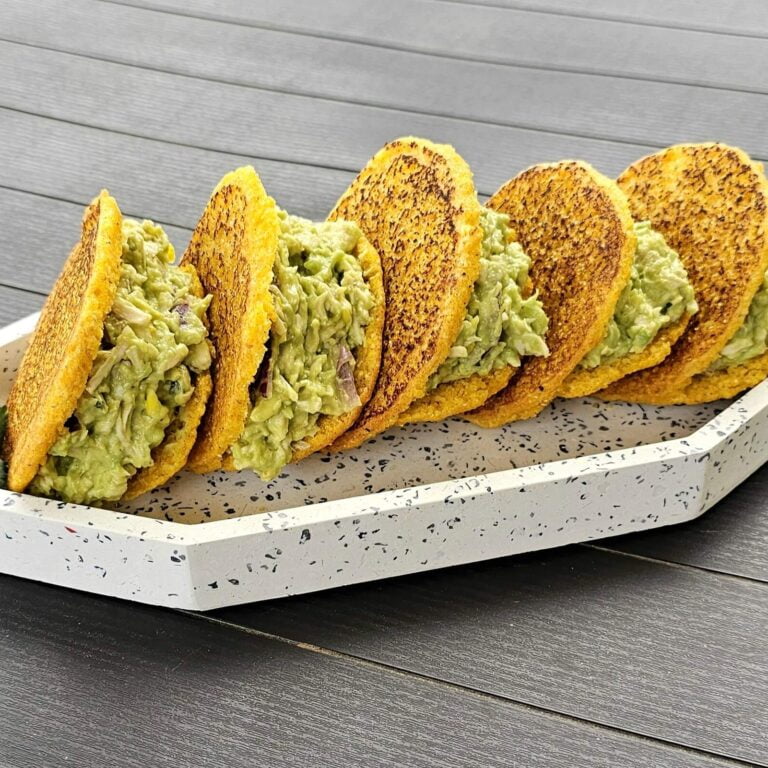 Gorditas with chicken and avocado on a plate, garnished with fresh herbs and served with sauces.