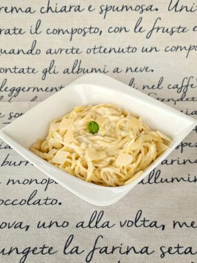 A plate of Quattro Formaggi Pasta garnished with parsley and freshly grated parmesan.