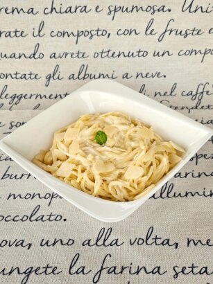 A plate of Quattro Formaggi Pasta garnished with parsley and freshly grated parmesan.